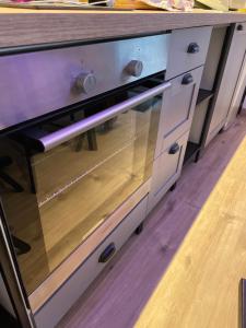 a wooden drawer with a glass door in a kitchen at Mille et une nuit, appartement classé 3 étoiles en RDC avec exterieur et parking in Dole