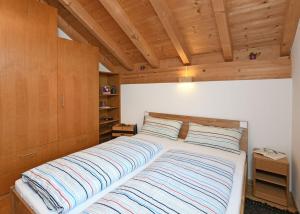Cama grande en habitación con techo de madera en h[AU]sblick, en Au im Bregenzerwald