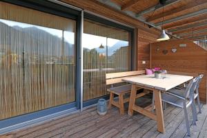 una terraza de madera con mesa y banco de madera en h[AU]sblick, en Au im Bregenzerwald