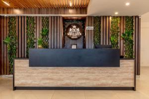 デヘラードゥーンにあるHotel White Rock By The Solitaire Hospitalityの植物のあるロビーの受付デスク