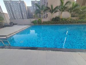 a large blue swimming pool in a city at Weekend Address Managed By P.C Homes in Surat