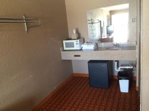 a bathroom with a sink and a microwave on a counter at Lake Shore Motel in Mannford +39 photos