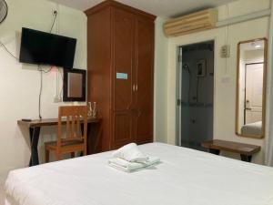 a bedroom with a bed and a desk and a television at MD House in Chiang Mai