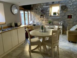a kitchen and dining room with a table and chairs at Chater Cottage Rothbury in Rothbury