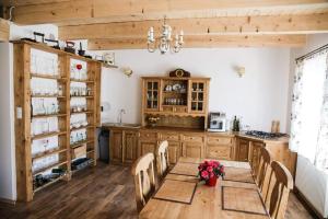 a kitchen with a wooden table with chairs and a dining room at Chata pod Świnią Górą * in Bliżyn