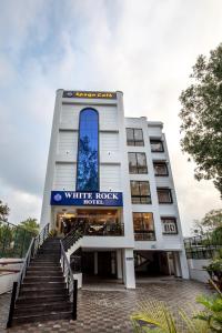 a white rock hotel building with stairs in front of it at Hotel White Rock By The Solitaire Hospitality in Dehradun