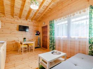 a living room with a table in a wooden cabin at Domki Letniskowe Słoneczna Przystań in Ustka