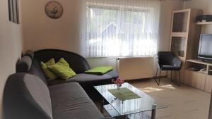 uma sala de estar com um sofá e uma mesa de vidro em Ferienwohnung-Nickl em Kleingießhübel
