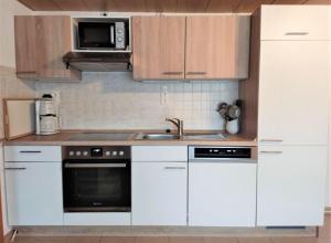 Kleingießhübel的住宿－Ferienwohnung-Nickl，厨房配有白色橱柜、水槽和微波炉
