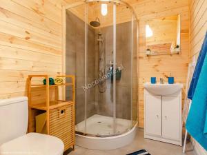 a bathroom with a shower with a toilet and a sink at Domki Letniskowe Słoneczna Przystań in Ustka