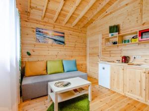 a living room with a couch in a wooden cabin at Domki Letniskowe Słoneczna Przystań in Ustka +8 photos