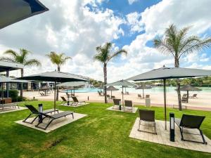 a park with chairs and umbrellas and a beach at THE BLYDE CRISTAL LAGOON in Pretoria