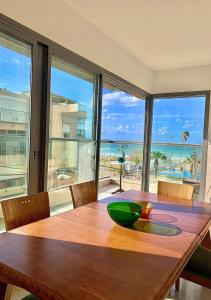 a dining room table with a view of the ocean at Beach Apartments in Haifa