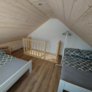 a attic room with two beds and a staircase at Domek Zacisze Gór Słonnych in Tyrawa Wołoska