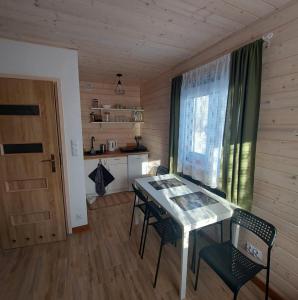 a room with a table and chairs and a window at Domek Zacisze Gór Słonnych in Tyrawa Wołoska