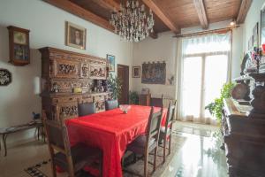 uma sala de jantar com uma mesa vermelha e cadeiras em Casa Eden em Veneza
