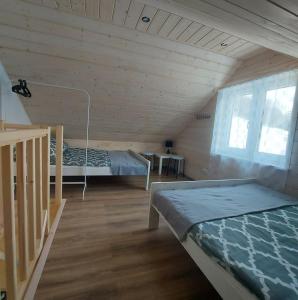 um quarto com 2 camas num chalé de madeira em Domek Zacisze Gór Słonnych em Tyrawa Wołoska