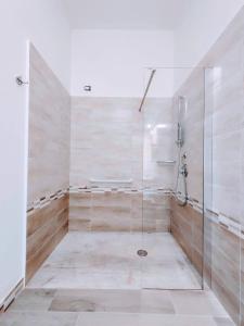 baño con ducha y puerta de cristal en Sa Banita affittacamere, en Bauladu