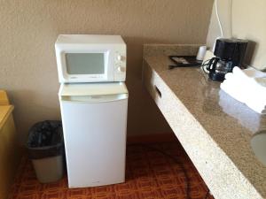 a microwave sitting on top of a refrigerator in a hotel room at Lake Shore Motel in Mannford