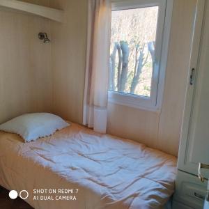 a bed in a room with a window at La maison des loirs in Valréas