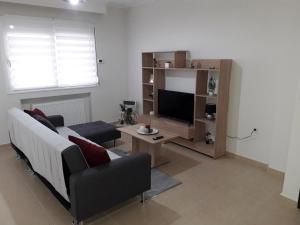 - un salon avec un canapé et une télévision dans l'établissement serres@home, à Serres