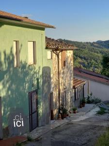 een groen gebouw met een bord aan de zijkant bij Casa Il Cecio in Roccalbegna