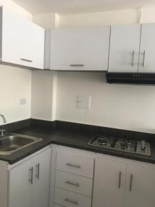 a kitchen with white cabinets and a sink and a stove at Mar de Indias House in Cartagena de Indias