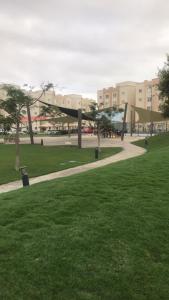 a park with a sidewalk and a building in the background at شقة في مدينة الملك عبدالله الاقتصادية حي الشروق in King Abdullah Economic City