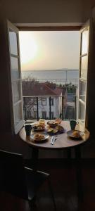 einen Tisch mit Teller mit Lebensmitteln und Meerblick in der Unterkunft Xavier - Alfama Apartment River View in Lissabon