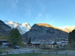 ein Dorf in den Bergen mit schneebedeckten Bergen in der Unterkunft Casa Dolonne - A un passo dallo sci in Courmayeur