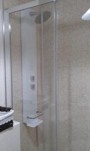 una ducha con puerta de cristal en un baño en Ático en pleno centro de Baiona con garaje, en Baiona