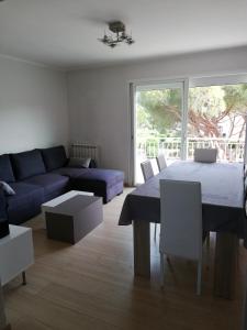 a living room with a blue couch and a table at Station balnéaire Pradet entre Toulon et Hyères proche plages in Le Pradet