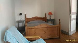 een slaapkamer met een houten bed en twee eindtafels bij Le gite du Mont in Val Couesnon