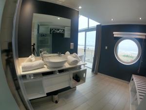 a bathroom with a sink and a large mirror at AT THE SEA Boutique Guesthouse in Swakopmund