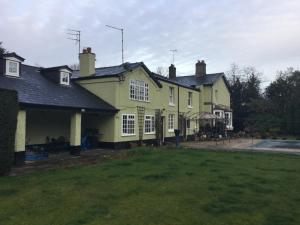 a large yellow house with white windows and a yard at Ground floor apartment in The Coach House in Hartford