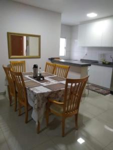 mesa de comedor con sillas y cocina en Apto inteiro Seguro e Confortável com piscina, en Anápolis