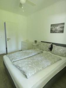 ein weißes Schlafzimmer mit einem Bett in einem Zimmer in der Unterkunft Gartenwohnung JULIANA Gstadt LÄUFERs CHIEMSEE HOLIDAY HOME in Gstadt am Chiemsee
