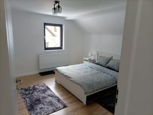 biała sypialnia z łóżkiem i oknem w obiekcie Center House w mieście Ramingstein