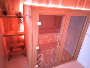 un armario de madera con una puerta de cristal en una habitación en Vakantiewoning EL COULEYE, en Durbuy