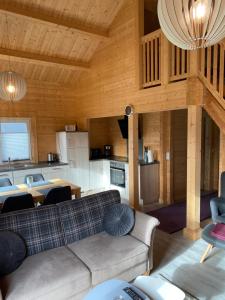 a living room with a couch and a kitchen at Ferienhaus am Harkebrügger See in Barßel