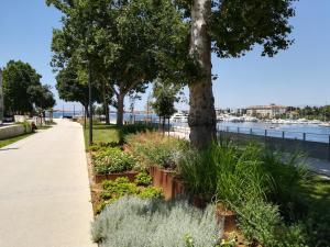 a park with flowers and trees and a sidewalk at Sea View Studio Apartment in Zadar