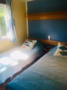 - une chambre avec 2 lits jumeaux à côté d'une fenêtre dans l'établissement Mobil-Home LA PALMYRE - Zoo, plage, animations, aux Mathes