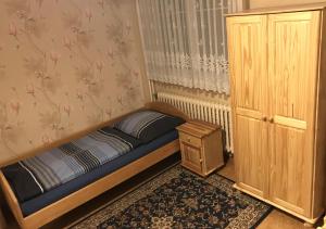 ムラダー・ボレスラフにあるModrý Pensionの小さなベッドルーム(ベッド1台、木製キャビネット付)