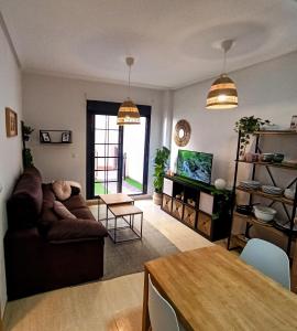 uma sala de estar com um sofá e uma mesa em Apartamento con Piscina Terraza y Parking em El Campello