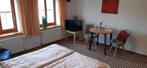 um quarto com uma cama, uma mesa e uma televisão em Landgut Hoppstall em Winterfeld