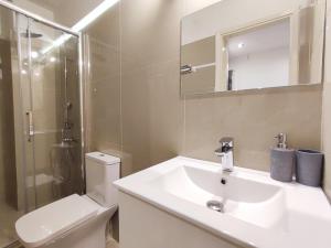 uma casa de banho com um lavatório, um WC e um espelho. em Avli apartment em Atenas