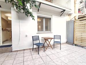 um pátio com 2 cadeiras e uma mesa em Avli apartment em Atenas