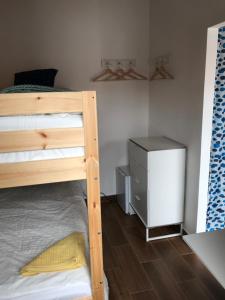 a bedroom with a bunk bed and a dresser at Quarto Santo António in Zambujeira do Mar