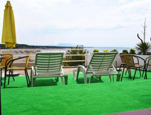 un gruppo di sedie a sdraio e un ombrellone in spiaggia di Apartments Kepi Gjerana a Ulcinj