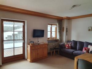 a living room with a couch and a tv at Ferienwohnung Haiber in Obermaiselstein